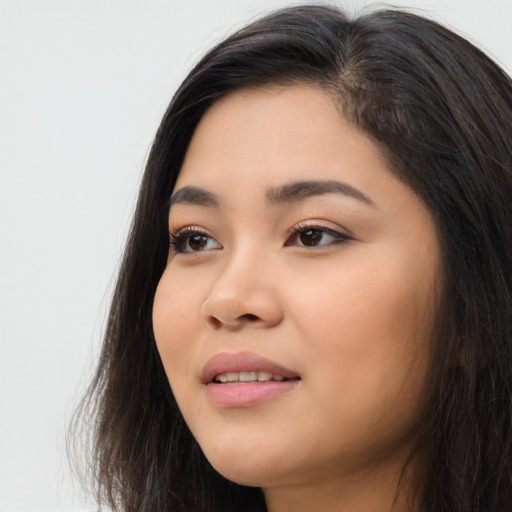Joyful latino young-adult female with long  brown hair and brown eyes