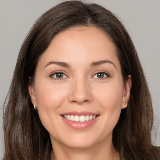 Joyful white young-adult female with long  brown hair and brown eyes