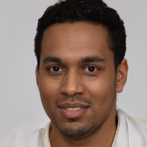 Joyful black young-adult male with short  black hair and brown eyes