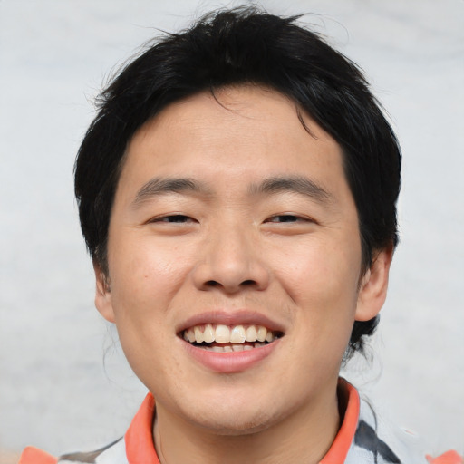 Joyful asian young-adult male with medium  brown hair and brown eyes