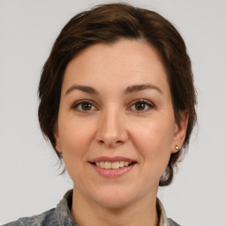 Joyful white young-adult female with medium  brown hair and grey eyes