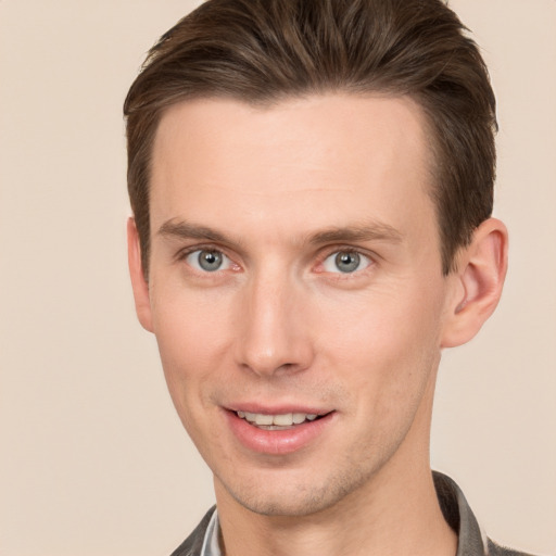 Joyful white young-adult male with short  brown hair and grey eyes