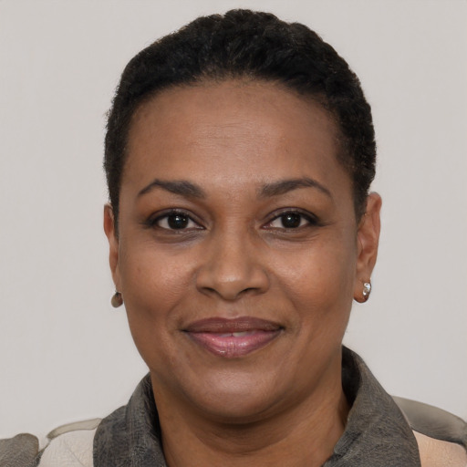 Joyful black adult female with short  black hair and brown eyes