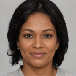 Joyful black adult female with medium  brown hair and brown eyes