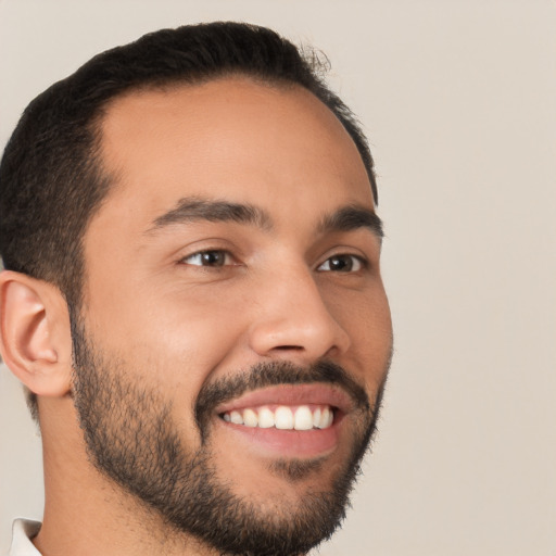 Joyful latino young-adult male with short  black hair and brown eyes