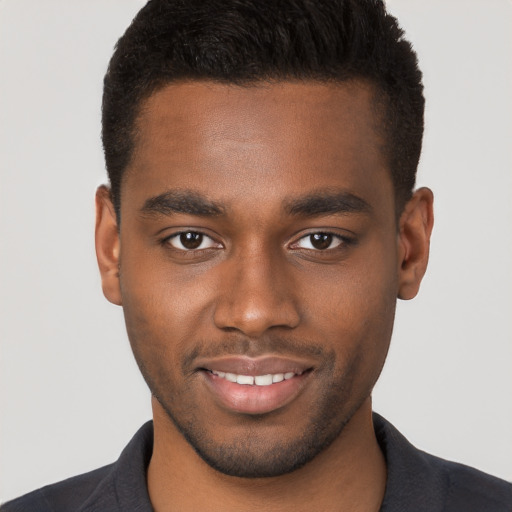 Joyful black young-adult male with short  brown hair and brown eyes