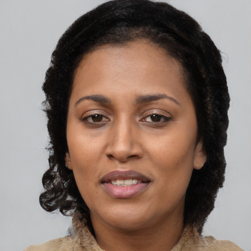 Joyful black adult female with long  brown hair and brown eyes