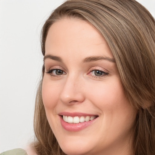 Joyful white young-adult female with long  brown hair and green eyes