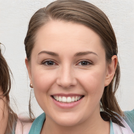 Joyful white young-adult female with medium  brown hair and blue eyes