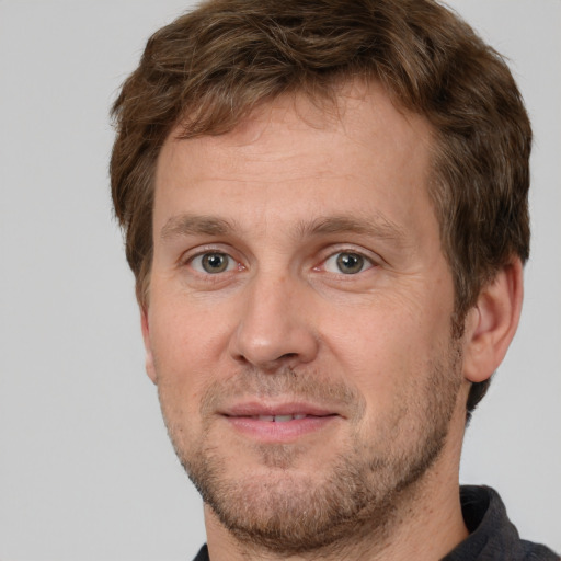 Joyful white adult male with short  brown hair and grey eyes