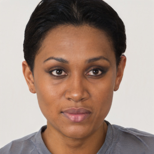 Joyful black young-adult female with short  black hair and brown eyes