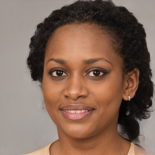 Joyful black young-adult female with long  brown hair and brown eyes