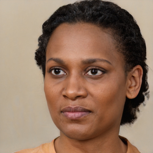 Joyful black young-adult female with short  black hair and brown eyes