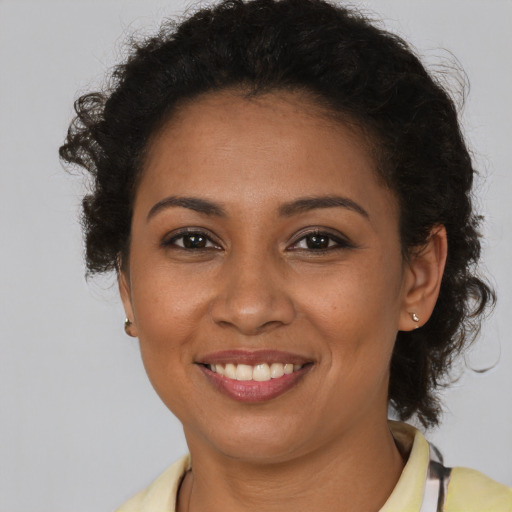 Joyful black young-adult female with short  brown hair and brown eyes