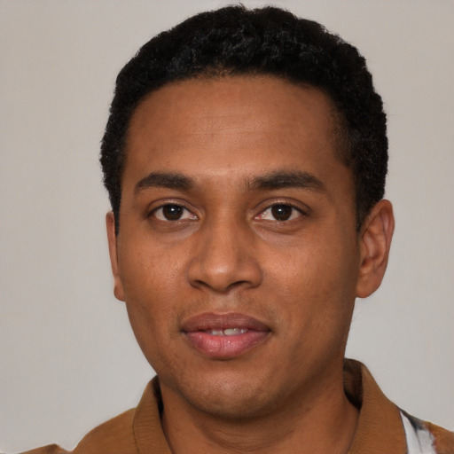 Joyful black young-adult male with short  black hair and brown eyes