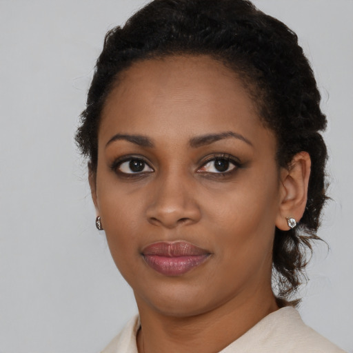 Joyful black young-adult female with medium  black hair and brown eyes