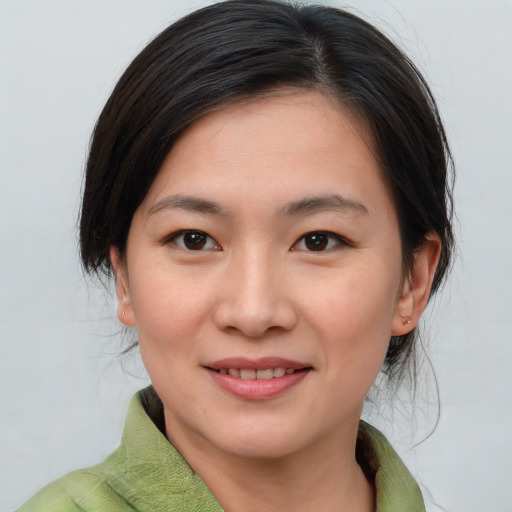 Joyful asian young-adult female with medium  brown hair and brown eyes
