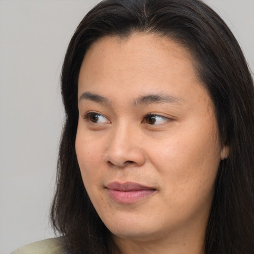 Joyful asian young-adult female with long  brown hair and brown eyes