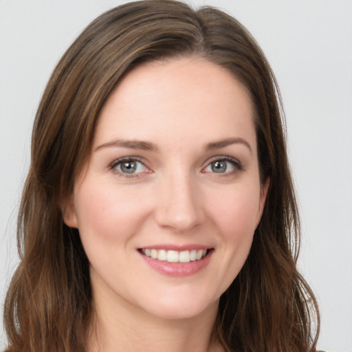 Joyful white young-adult female with long  brown hair and grey eyes