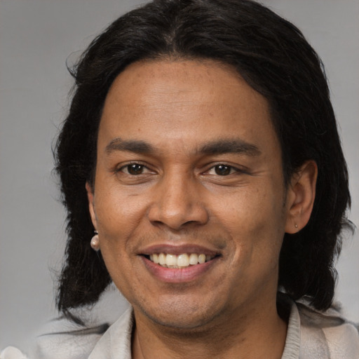 Joyful latino adult male with medium  brown hair and brown eyes