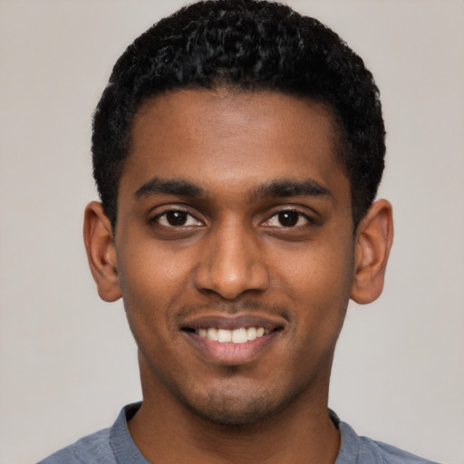 Joyful black young-adult male with short  black hair and brown eyes