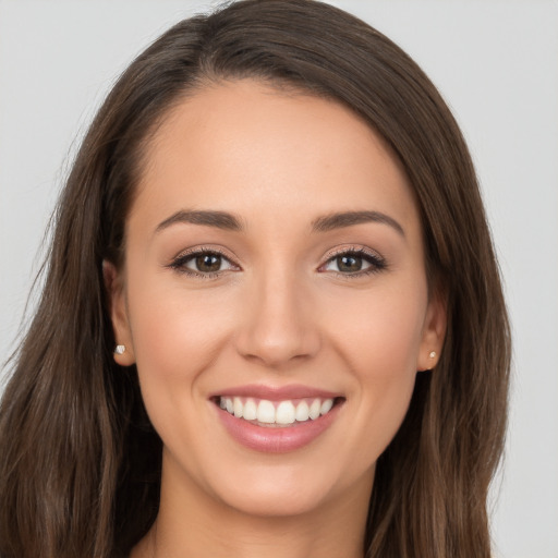 Joyful white young-adult female with long  brown hair and brown eyes