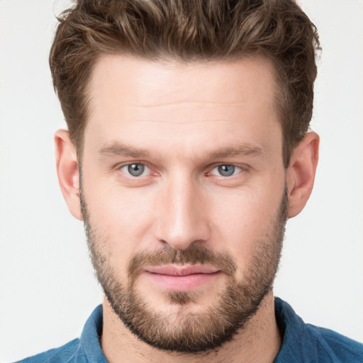 Joyful white young-adult male with short  brown hair and grey eyes