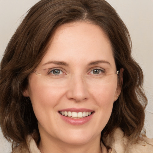 Joyful white adult female with medium  brown hair and grey eyes