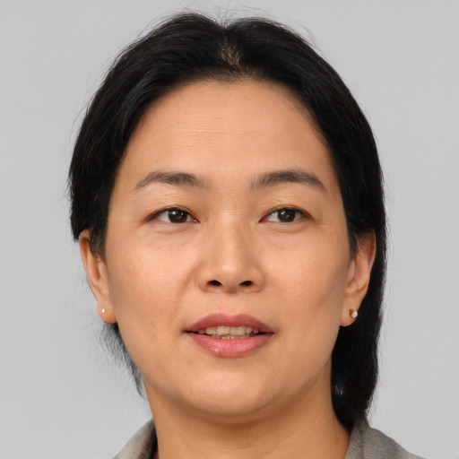 Joyful asian adult female with medium  brown hair and brown eyes