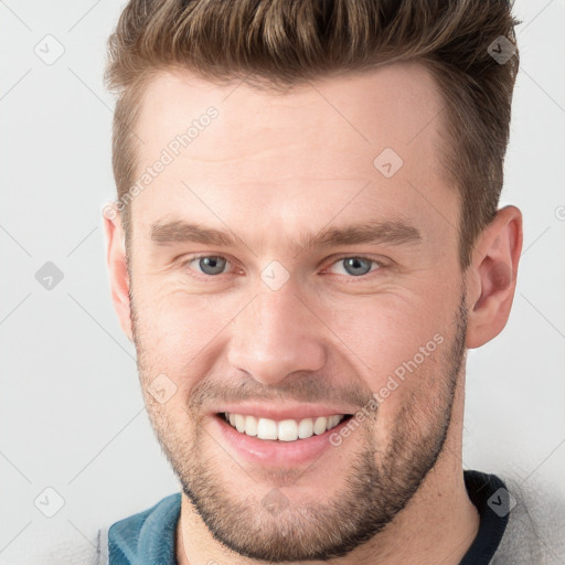 Joyful white young-adult male with short  brown hair and grey eyes