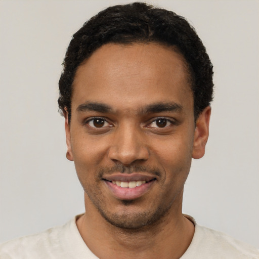 Joyful black young-adult male with short  black hair and brown eyes