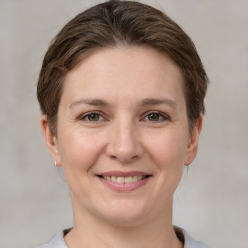 Joyful white young-adult female with short  brown hair and grey eyes