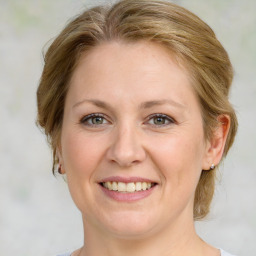 Joyful white adult female with medium  brown hair and green eyes