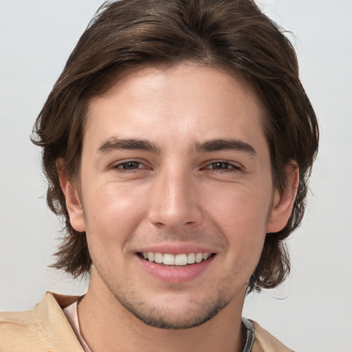 Joyful white young-adult male with medium  brown hair and brown eyes