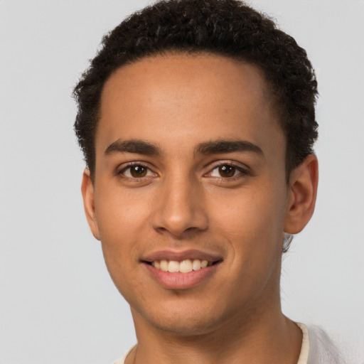 Joyful latino young-adult male with short  brown hair and brown eyes