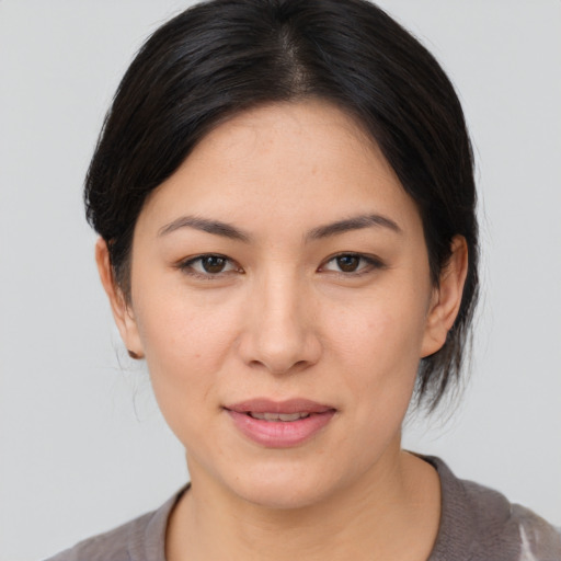 Joyful asian young-adult female with medium  brown hair and brown eyes