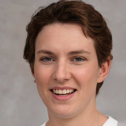 Joyful white young-adult female with short  brown hair and grey eyes