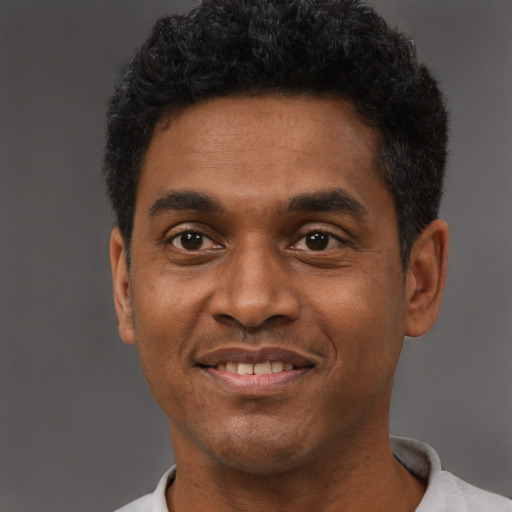 Joyful black young-adult male with short  black hair and brown eyes