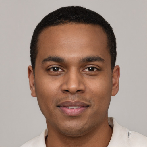 Joyful black young-adult male with short  black hair and brown eyes