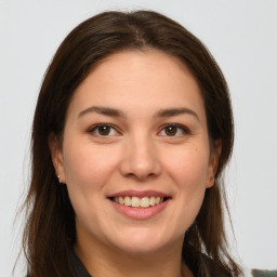 Joyful white young-adult female with long  brown hair and brown eyes