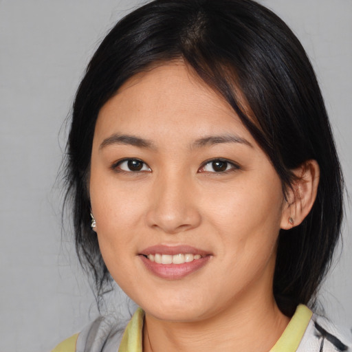 Joyful asian young-adult female with medium  brown hair and brown eyes