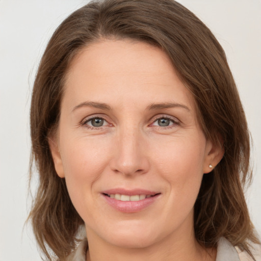 Joyful white adult female with medium  brown hair and grey eyes