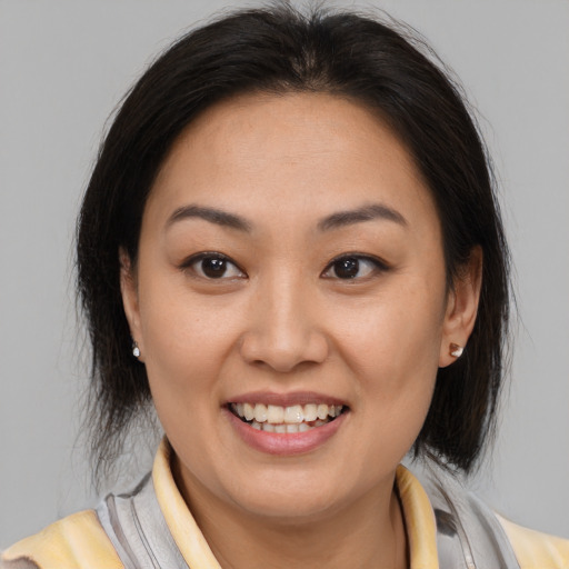 Joyful latino young-adult female with medium  brown hair and brown eyes