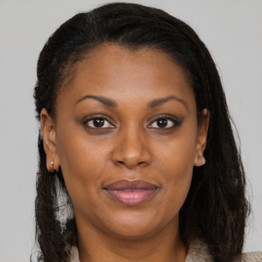 Joyful black adult female with medium  brown hair and brown eyes
