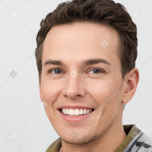 Joyful white young-adult male with short  brown hair and brown eyes