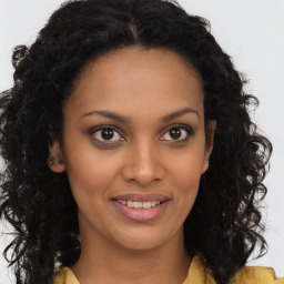 Joyful black young-adult female with long  brown hair and brown eyes