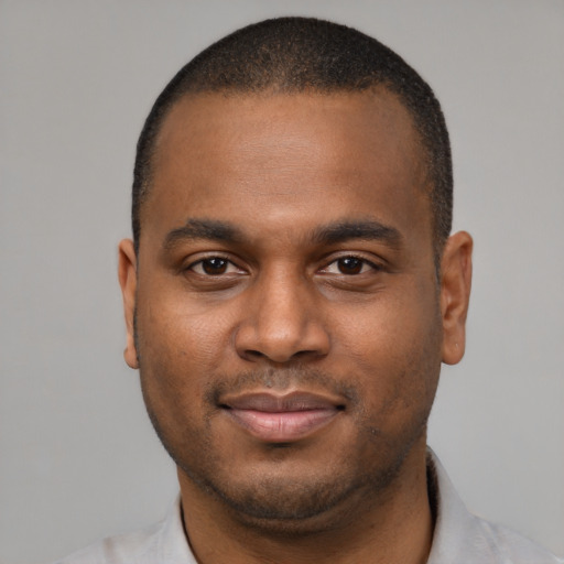 Joyful black young-adult male with short  brown hair and brown eyes