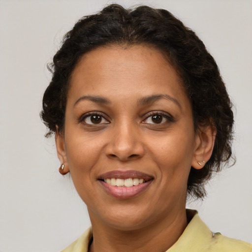 Joyful latino adult female with short  brown hair and brown eyes