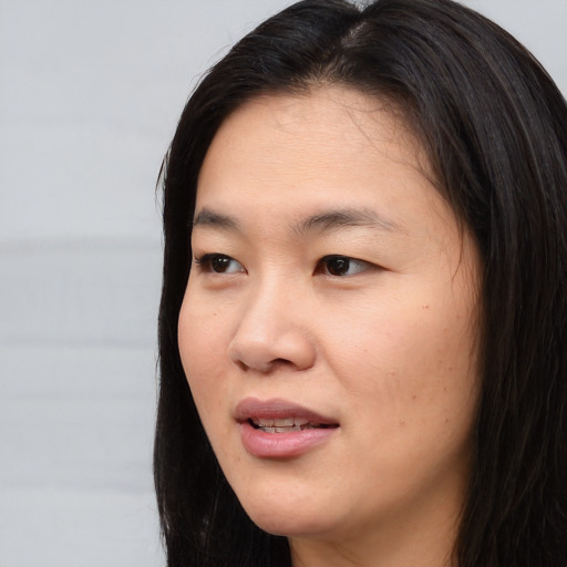 Joyful asian young-adult female with long  black hair and brown eyes