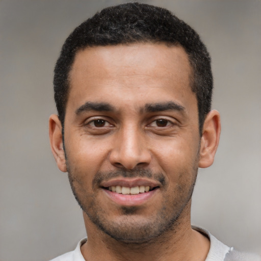 Joyful latino young-adult male with short  black hair and brown eyes